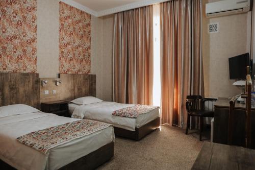 布哈拉奥马尔希亚姆酒店的酒店客房配有两张床和一张书桌