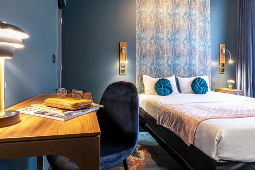 巴黎Hotel Glasgow Monceau by Patrick Hayat的酒店客房配有一张床、一张书桌