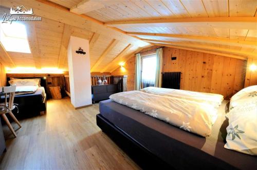 利维尼奥Mountain Chalet Scoiattolo的一间卧室设有两张床和木制天花板