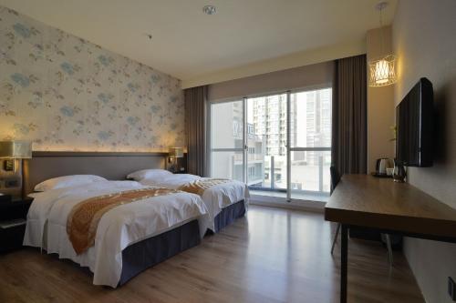 新竹晶悦精品旅馆 的酒店客房设有两张床和电视。