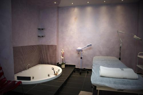 都灵一都灵住宅酒店的带浴缸的浴室和一张床。