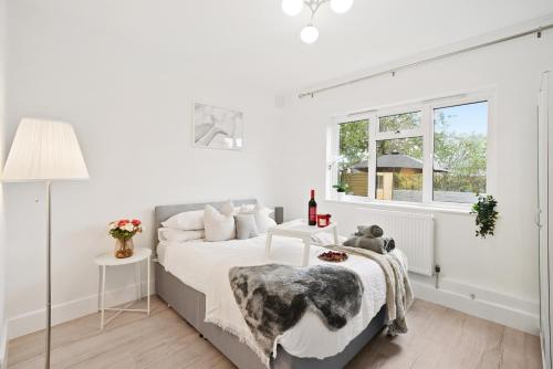 伦敦LiveStay-Stylish Two Bed House with Private Garden的白色的卧室设有床和窗户