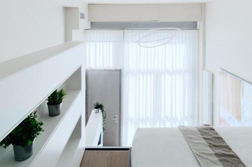 米兰Touch&Go - via Gaetano Previati 38, Milano的一间白色的卧室,配有床和楼梯