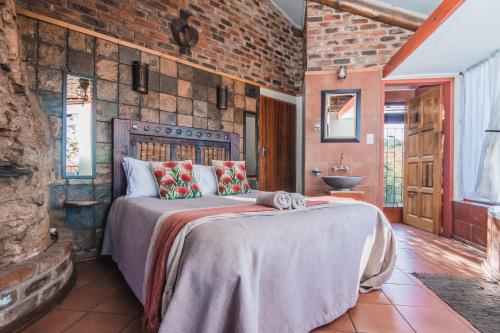 帕雷斯Thabela Thabeng的卧室设有一张砖墙内的大床