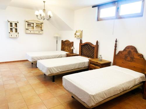 希洪Casa Román III的白色墙壁客房的两张床