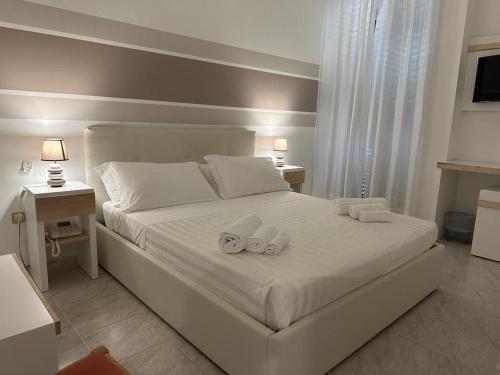 切萨雷奥港Porto Cesareo Hotel的卧室配有白色的床和2条毛巾