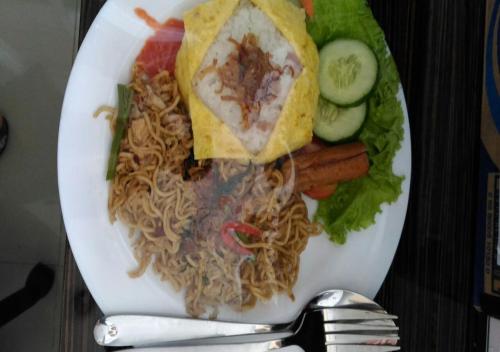 明古鲁省Omnea Hotel - Syariah的餐桌上一盘带面条和蔬菜的食物