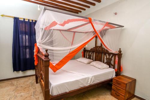 南威Majani Breeze的一间卧室配有一张带蚊帐的床
