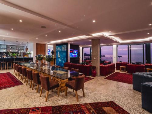 赫曼努斯Boutique Ocean Views - incorporating Wendy's的一间带桌椅的用餐室和一间酒吧
