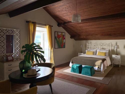 VárzeaVilla Várzea - Charming Suite的一间卧室配有一张床、一张桌子和一个窗户。
