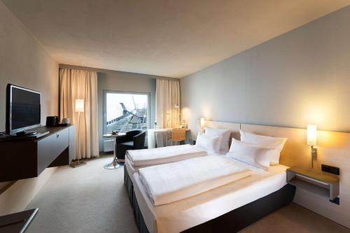 不莱梅大西洋宇宙酒店的酒店客房设有一张大床和一台电视。
