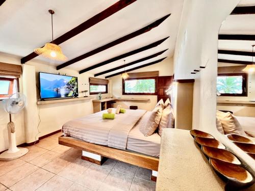 通萨拉Three rare & private front beach villas的一间卧室配有一张床和一台平面电视