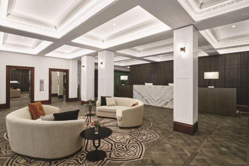 墨尔本墨尔本汇合酒店的大堂设有两张沙发、椅子和桌子
