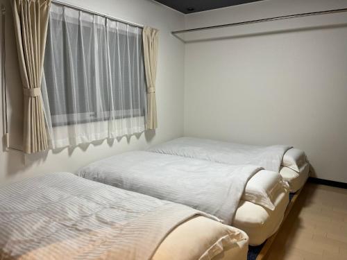 札幌ＡkＢ63的带窗户的客房内的两张床