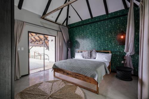 普拉伊拉多比莱尼Mukumbura Lodge Bilene的一间卧室设有一张床和绿色的墙壁