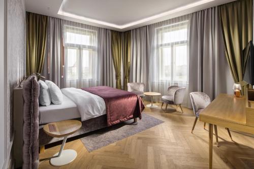 布拉格布拉格河畔马梅森酒店的卧室配有一张床、一张书桌和窗户。
