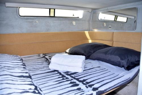 圣米格尔德阿沃纳Luxury Boat KARAMBA I的一张带两个枕头的床和两条毛巾
