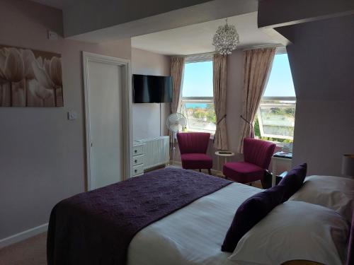 佩恩顿两个海滩旅馆的一间卧室配有一张床、两把椅子和一个窗户
