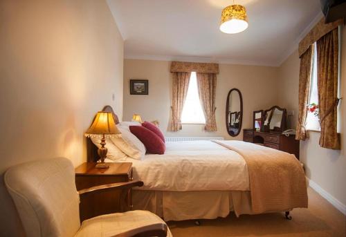 克利夫登敦瑞酒店的一间卧室配有一张床、一把椅子和一盏灯