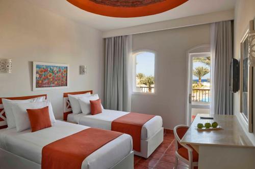 考拉亚湾Solymar Reef Marsa的酒店客房设有两张床和一张桌子。