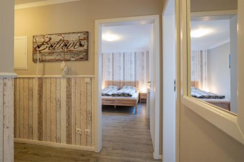 霍尔斯泰因地区诺伊斯塔特Premium Quartier Solymar Pelzerhaken的走廊上设有一张床和镜子的房间