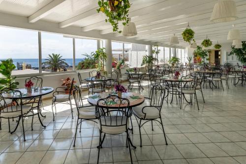 斯特龙博利Hotel Ossidiana Stromboli Center的用餐室设有桌椅和窗户。