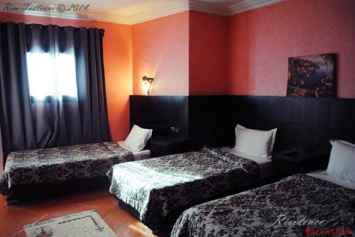 马拉喀什Marrakech Hôtel Résidence的酒店客房设有两张床和窗户。