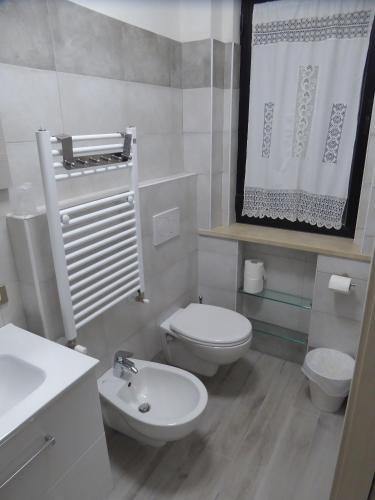 里米尼Affittacamere Vittoria的白色的浴室设有卫生间和水槽。