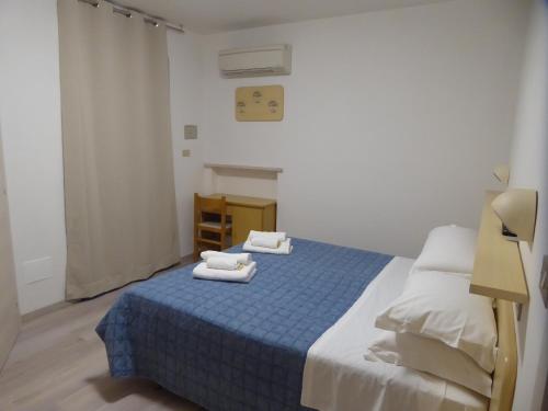 里米尼Affittacamere Vittoria的一间卧室配有蓝色的床和毛巾