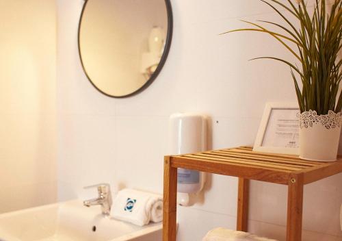 塞维利亚ISA Sevilla Suites的浴室设有镜子和桌子上的植物