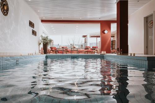 HeimbuchenthalPANORAMA Hotel Heimbuchenthal的一座配有桌椅的酒店游泳池
