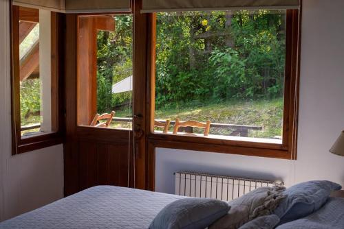 拉安戈斯图拉镇Casa del Sur Villa La Angostura的一间卧室设有一张床和一个美景窗户。