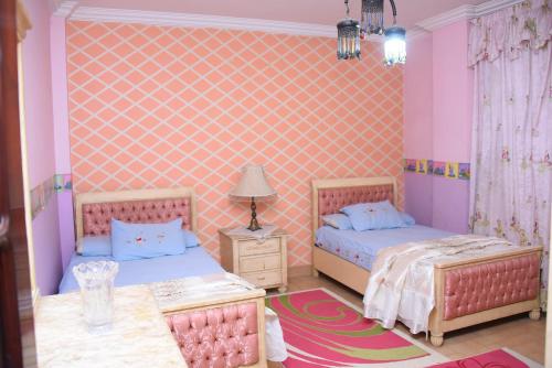 开罗Kenzy guest house的一间卧室配有两张床和一张桌子