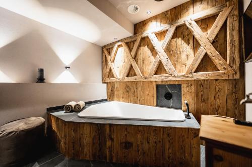 采尔马特艾尔畔霍夫健康酒店的木墙客房内的浴缸