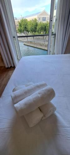 开普敦V&A Waterfront Marina Family Apartment 101 Altmore的两条毛巾,放在床边,窗户
