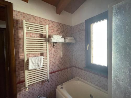 菲乌米奇诺奥拉公寓的带浴缸的浴室和粉红色的瓷砖墙