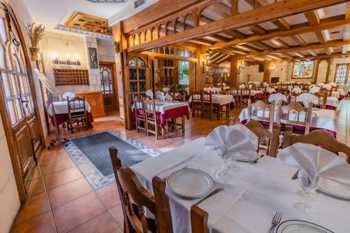 桑托多明戈德锡洛斯Apartamentos & casas rurales Santo Domingo de Silos的一间设有白色桌椅的用餐室