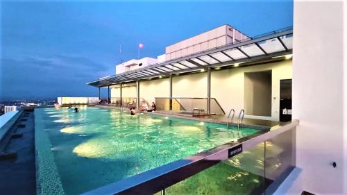 马六甲The Quartz Premium Travel Suites @Melaka的建筑物屋顶上的游泳池