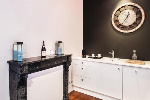 博讷拉梅森德斯科提尼斯酒店的一间带水槽和墙上时钟的浴室