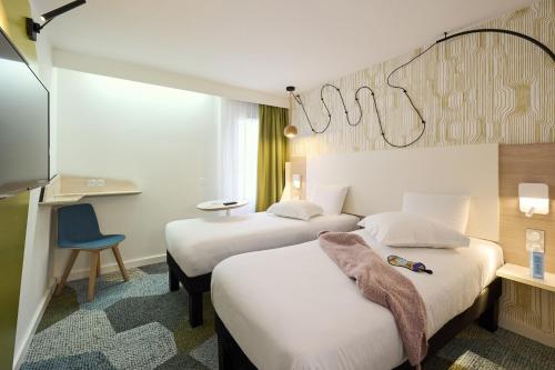 贝格莱ibis Styles Bordeaux Begles的酒店客房,配有两张床和椅子