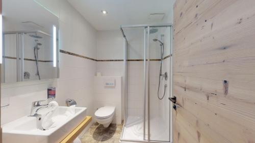 蒂罗尔-基希贝格Hotel Daxer的带淋浴、盥洗盆和卫生间的浴室