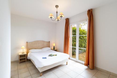 格里莫Garden & City Les Bastides de Grimaud的一间卧室设有一张床和一个大窗户