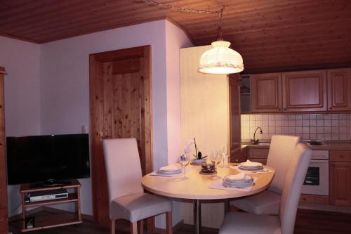 多弗加斯坦约翰娜公寓的厨房配有桌椅和电视。