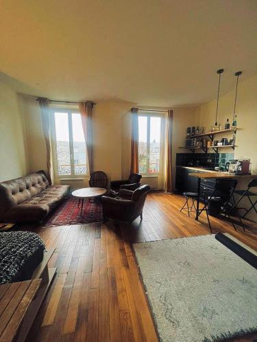 巴黎Villa Ermitage-Appartement Paris - Buttes Chaumont的客厅配有沙发和桌子
