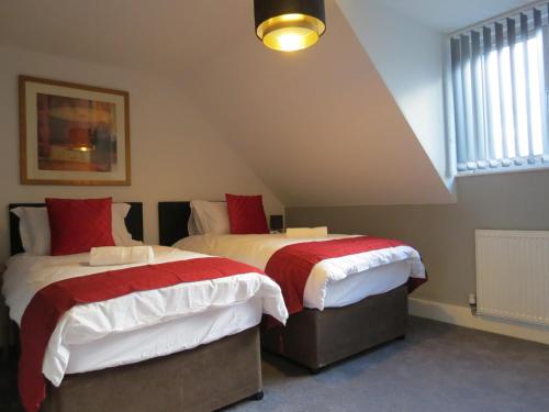 泰恩河畔纽卡斯尔Eazy apartments的一间卧室配有两张带红白毯子的床