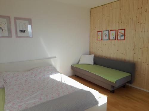 GreithMinihaus in den Bergen/ Small mountain house的一间卧室配有一张床和一张沙发