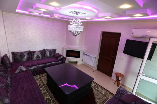 伊夫兰APPARTEMENT AMIRA iFRANE的紫色的客厅配有沙发和电视