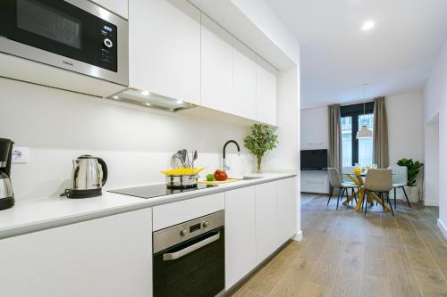 马德里Feelathome Castilla Apartments的厨房配有白色橱柜和台面