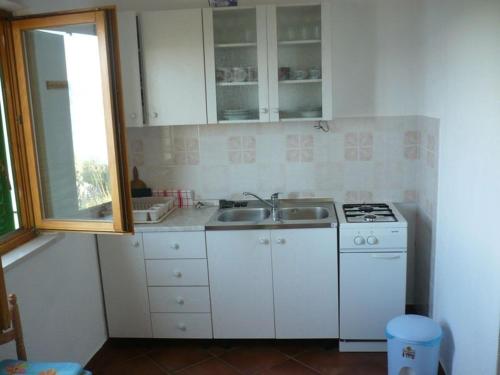 穆尔维察Robinson home for 3-4 Pers in Murvica 18-1的厨房配有炉灶、水槽和窗户。