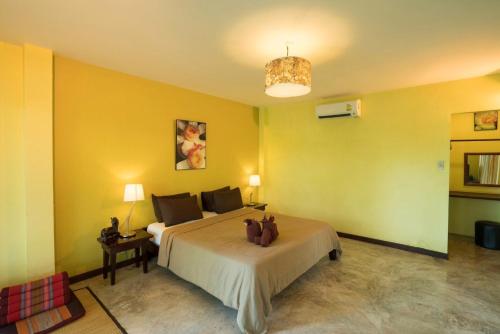 夜功府River CoCo @ Amphawa的一间卧室设有一张大床和黄色的墙壁